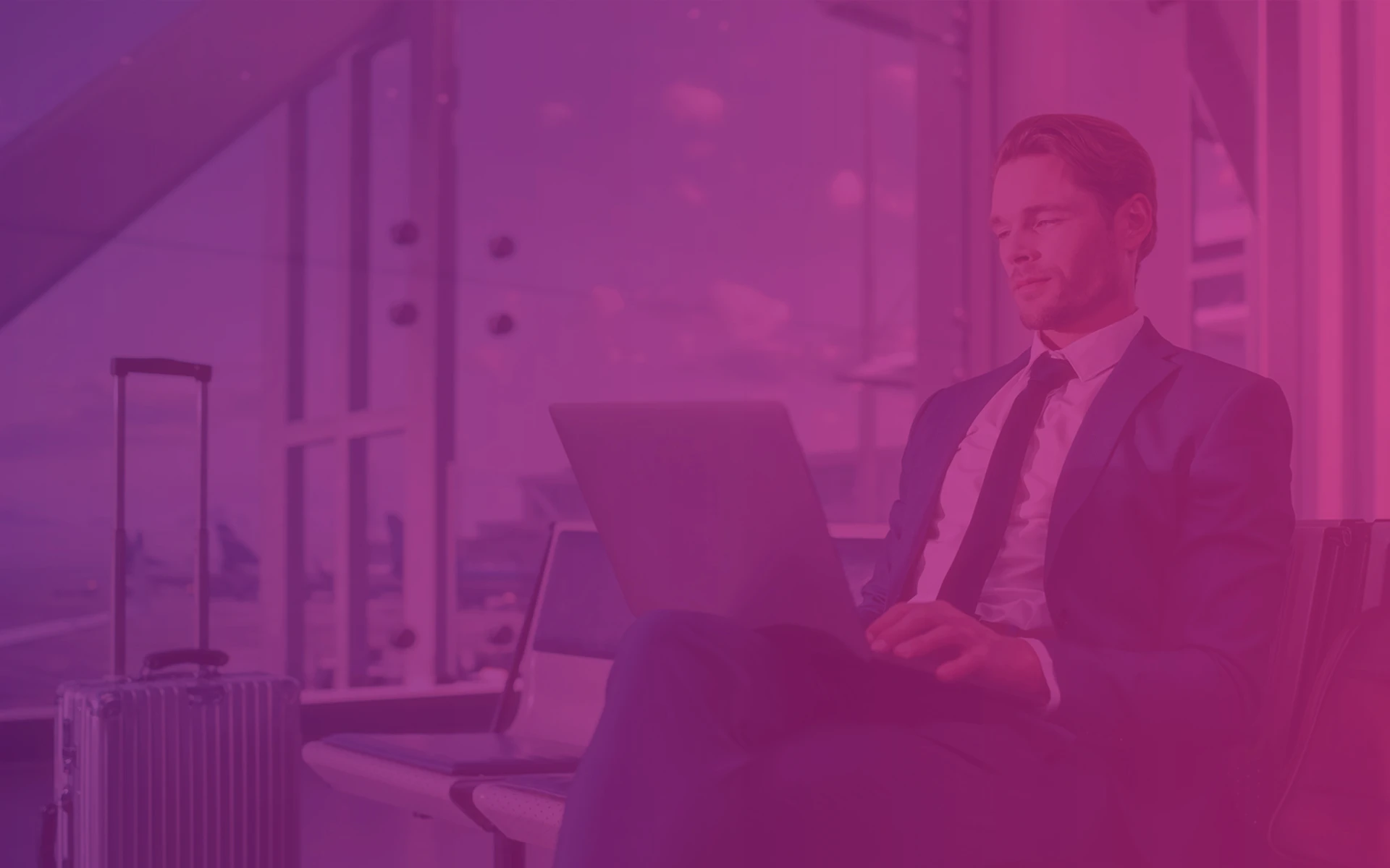 Man sitting by laptop on his laps, wearing suit. Photo of the man is covered by purple-pink filter. Graphic for blog website of Transition Technologies PSC, related to blogpost about Vacation Manager for Jira