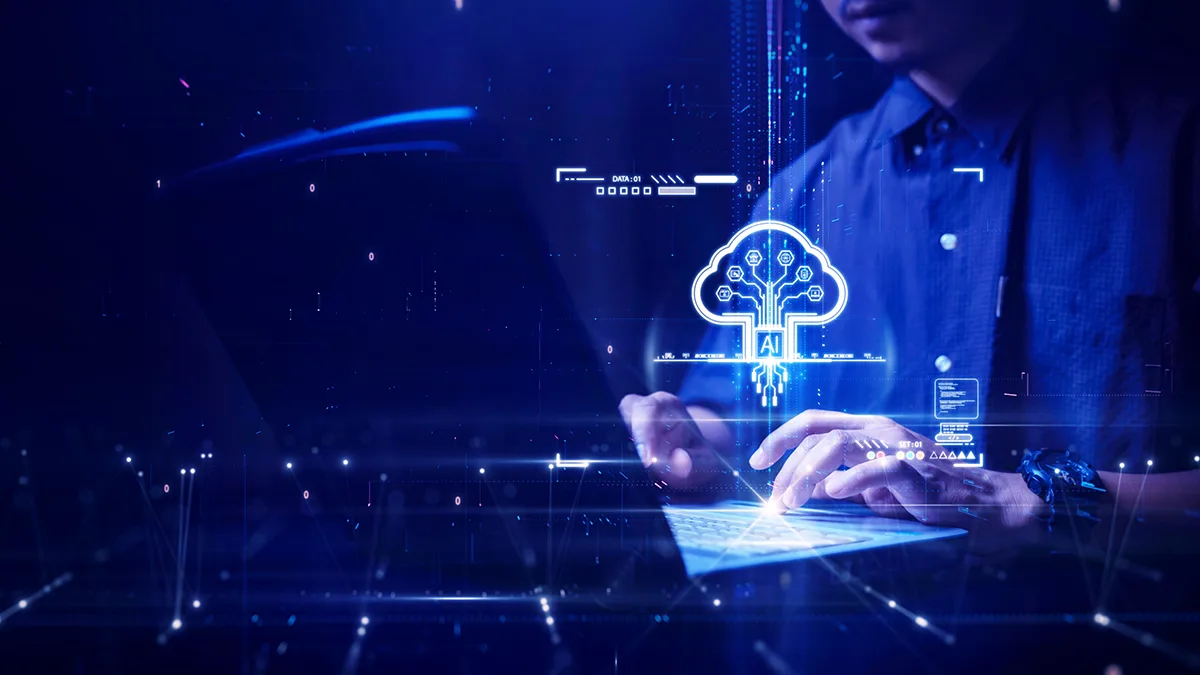 Projekt graficzny z ciemnoniebieskim tłem i grafiką cyfrową sugerującą technologię i innowację. Po prawej stronie znajduje się nakładka przedstawiająca osobę piszącą na laptopie, symbolizująca aktywną pracę w technologii. Ten obraz wizualnie przedstawia przecięcie się interakcji człowieka z zaawansowanymi technologiami obliczeniowymi, podkreślając temat wpływu AI na przyszłe krajobrazy technologiczne, szczególnie w zakresie przetwarzania w chmurze.