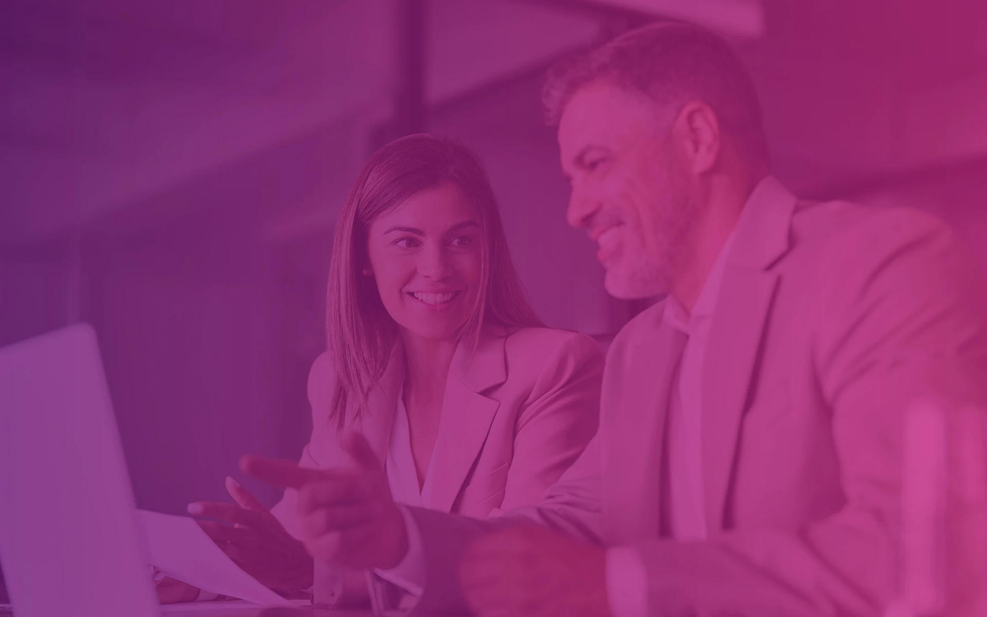 Grafika do tła kafelka w sekcji ze wszystkimi blogpostami na stronie firmy Transition Technologies PSC, grafika przedstawia mężczyznę i kobietę siedzących w biurze przy laptopach, ubranych w marynarki. Na fotografię nałożony został fioletowo-różowy gradientowy filtr zgodny z identyfikacją wizualną firmy Transition Technologies PSC. Grafika nie zawiera żadnych tekstów. A graphic for the background tile in the section with all blogposts on the Transition Technologies PSC company website, the graphic shows a man and a woman sitting in an office at laptops, wearing jackets. A purple-pink gradient filter in line with Transition Technologies PSC's corporate identity was applied to the photograph. The graphic does not contain any text.