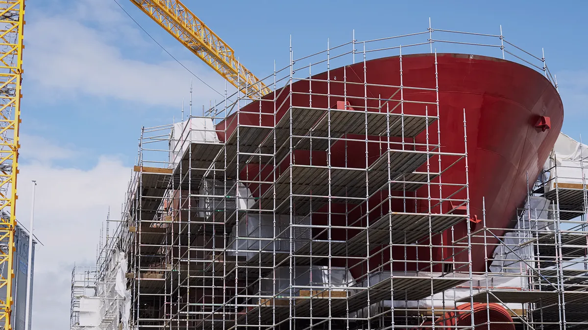 The image in the background of the blog entry by Transition Technologies PSC is a photograph of a ship's hull under construction, surrounded by scaffolding. The blog entry refers to the use of modern technologies in shipyards. The title of the article is: Results of the Mari4_YARD project: Augmented Reality (AR) in shipbuilding.