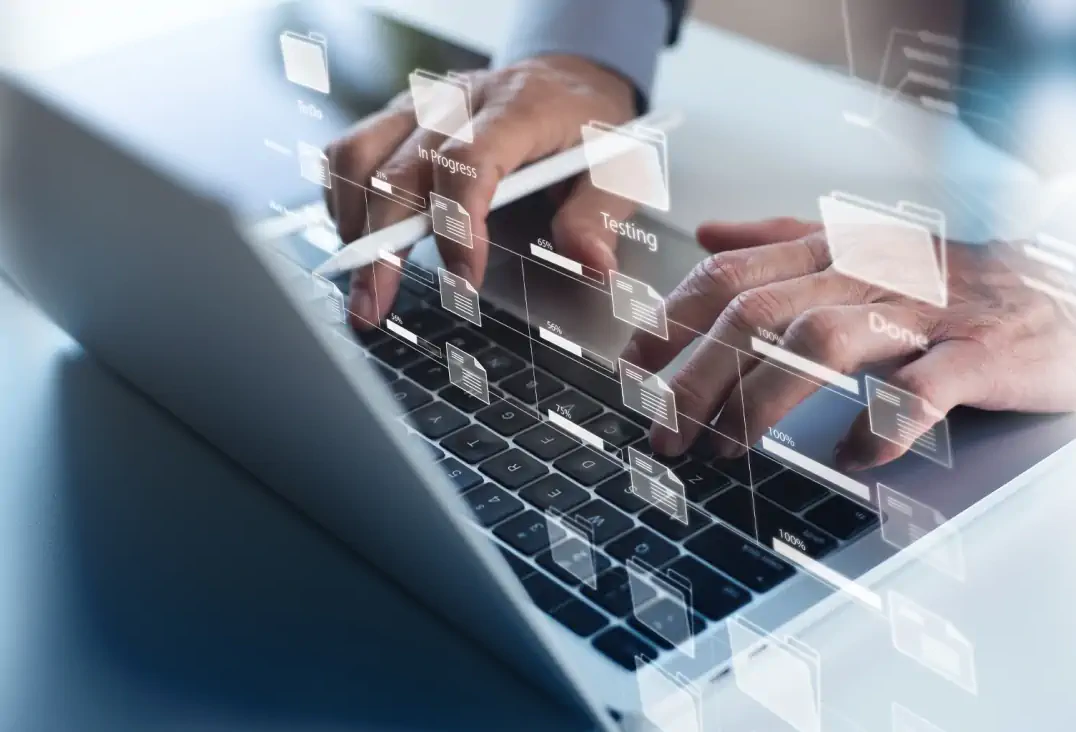 Person typing on a laptop keyboard with overlaid transparent digital interface