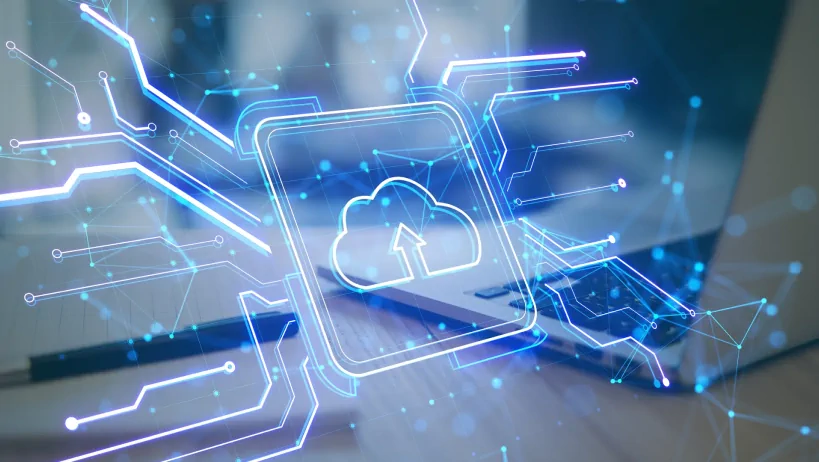 Digital cloud upload icon over a laptop, symbolizing cloud computing.