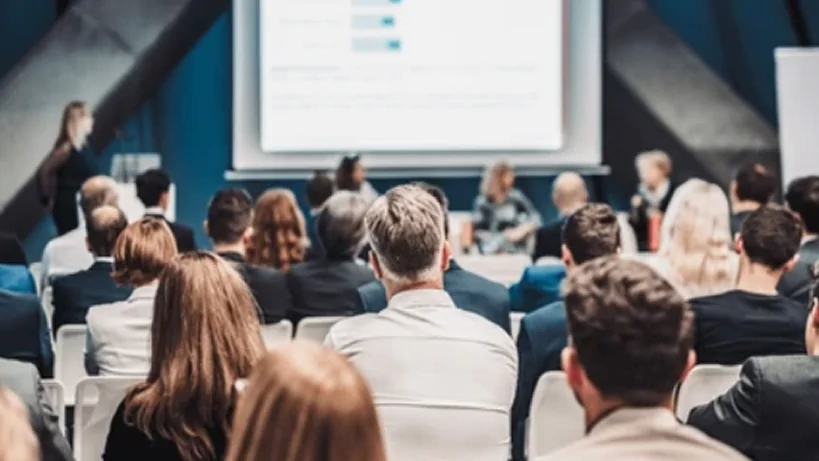 Uczestnicy konferencji słuchający prezentacji na temat biznesu lub technologii.