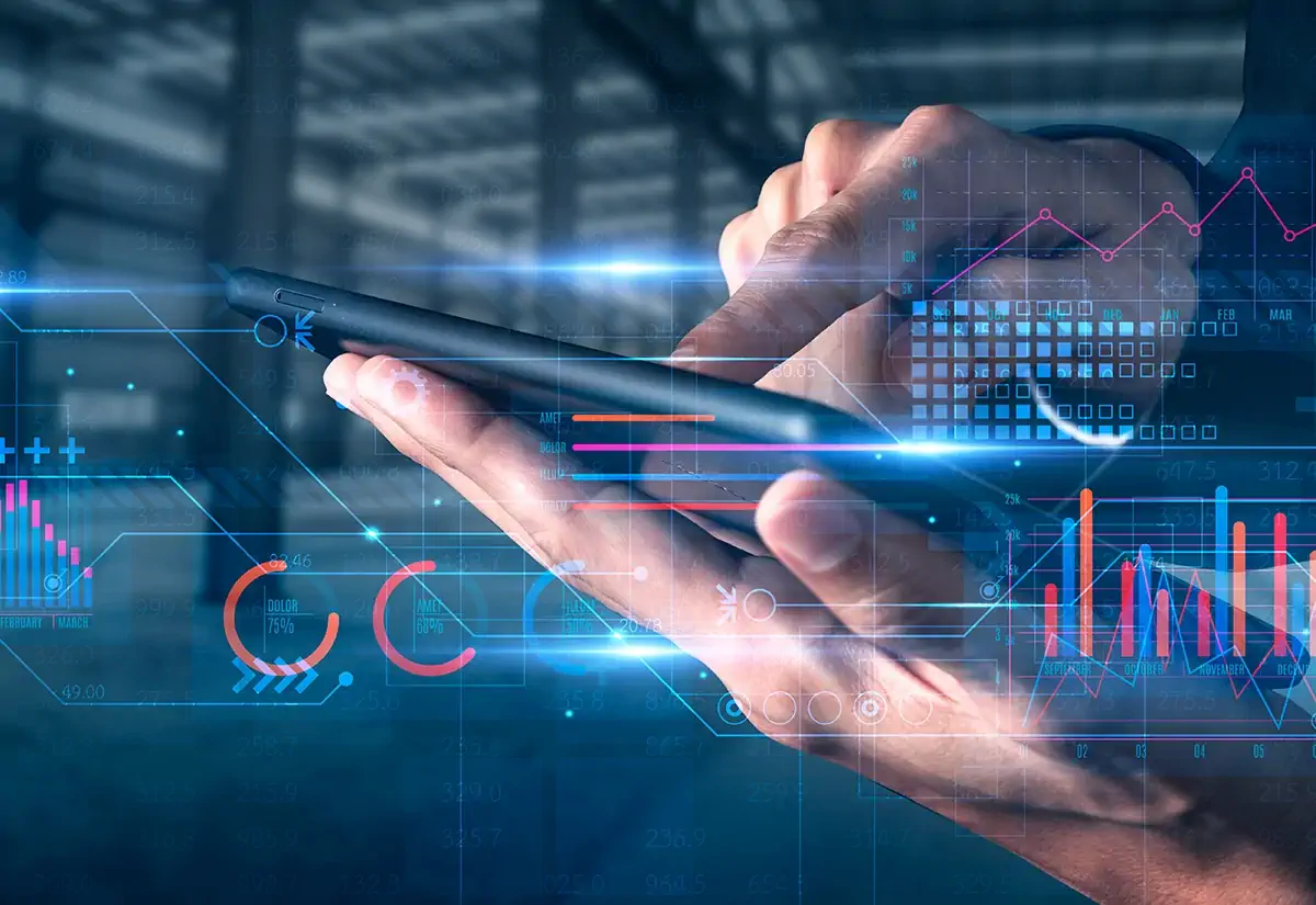 Hand holding a smartphone with digital charts and analytics overlay – representing business intelligence and digital transformation.