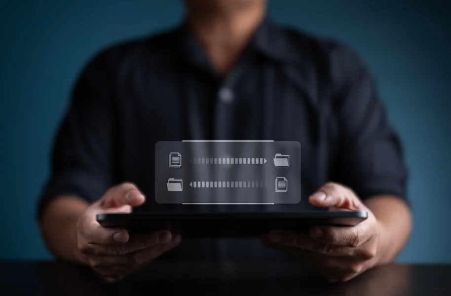 Man holding a tablet with icons for data transfer and cloud files