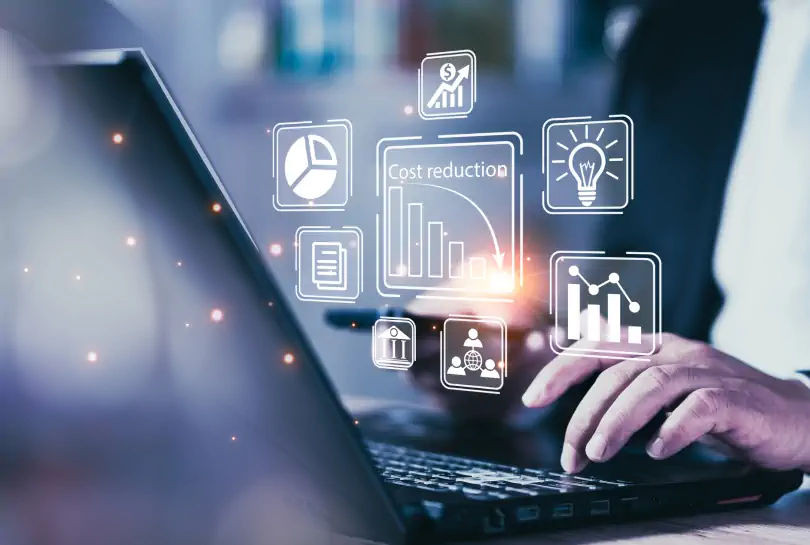 Biznesmen pracujący na laptopie z ikonami analityki i redukcji kosztów w technologii cyfrowej