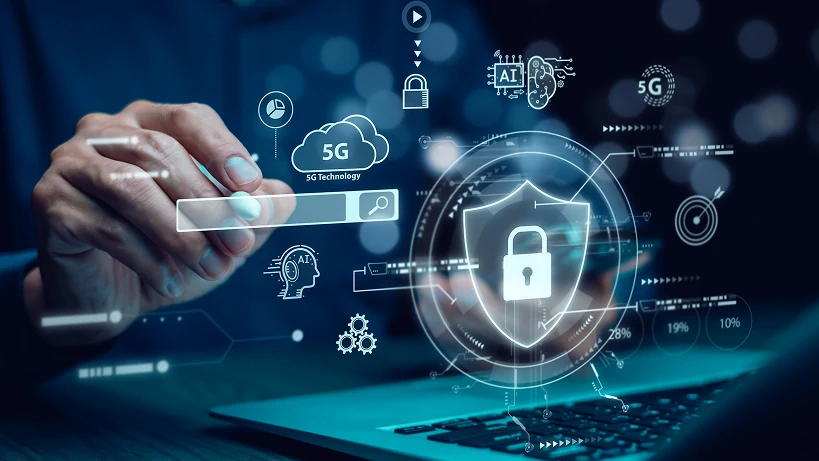 Ein Profi, der mit einem Laptop interagiert, umgeben von einer futuristischen digitalen Schnittstelle, die Cybersicherheitselemente, 5G-Konnektivität, KI und Cloud-Sicherheitssymbole anzeigt. Ein zentrales Schild mit einem Schloss symbolisiert Datenschutz, Compliance und Systemintegrität und unterstreicht die Bedeutung sicherer Audits und Überwachung in industriellen IoT-Umgebungen.